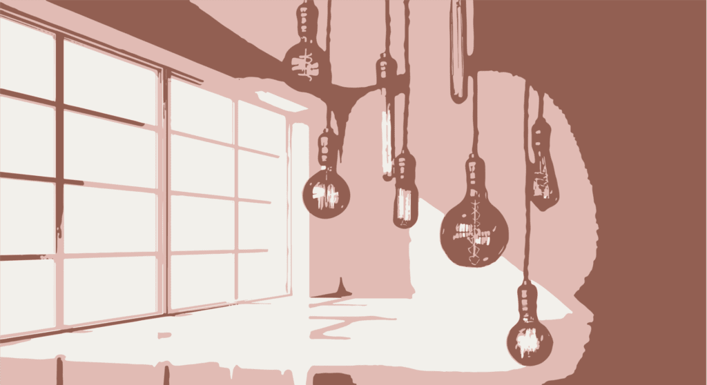 A variety of electric lightbulbs arranged in front of a window letting in natural daylight.